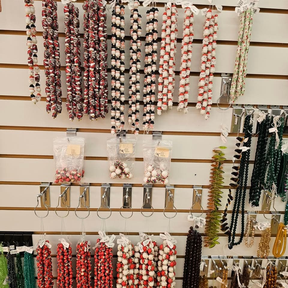 A slat-wall display hung with strands of beads and seed-bead packs